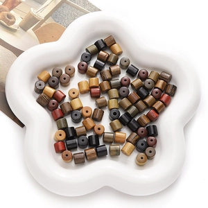 Macro view of assorted cylindrical natural wood beads in a white star-shaped ceramic tray