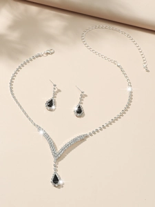 Close-up of teardrop black gem necklace and earrings set with silver lobster clasp