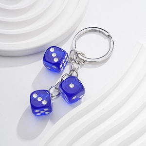 Close-up of three blue translucent dice charms on a silver metal keychain with ring
