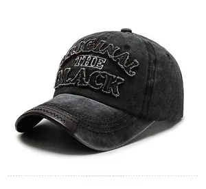 Detail of washed black baseball cap with 3D embroidery and brown leather brim edge