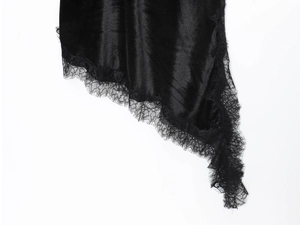 Détail du tissu en satin noir avec de la dentelle cils délicate sur l'ourlet de la robe