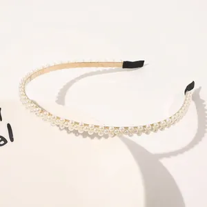 Detail of double-row white pearls on a slim gold metal headband for elegant bridal styling