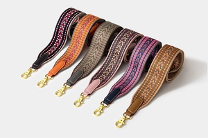 Collection of colorful woven bag straps with leather ends and gold lobster clasps