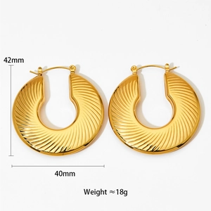 Detailed view of large gold hollow earrings with ribbed texture, 42mm size and 18g weight
