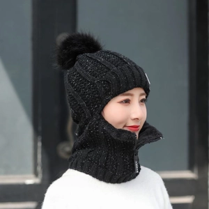 Détail de la capuche d'hiver en tricot noir avec tour de cou et pompon en fourrure