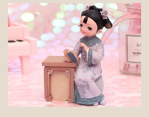 Detailed view of a purple resin girl figurine in ancient style reading at a desk