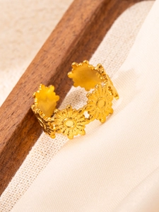 Detailed view of gold sunflower relief pattern on adjustable stainless steel band ring