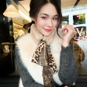 Close-up of faux fur scarf with leopard print ribbon and luxurious texture details