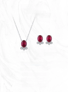Detail view of S925 silver necklace and earrings set with oval ruby gemstones