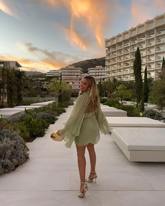 Kurzes minzgrünes Chiffon-Minikleid mit Rüschenärmeln und Saum in einer Resort-Umgebung