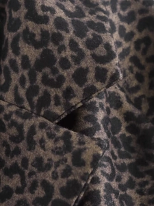 Detailed macro view of heavy wool-blend fabric texture with classic leopard print pattern