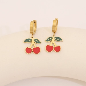 Détail de boucles d'oreilles cerise dorées avec revêtement en émail rouge et vert