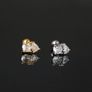 Macro shot of gold and silver geometric zircon cartilage studs with secure screw back balls