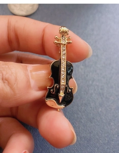 Detailed view of violin brooch pin with black enamel and sparkling rhinestones