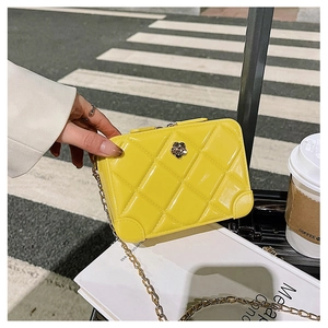 Close-up of a yellow quilted PVC jelly bag with a metal flower and gold chain strap