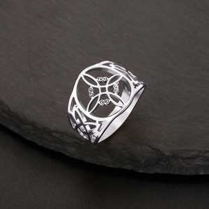 Vue détaillée d'une bague nœud de sorcière géométrique en acier sur une ardoise sombre