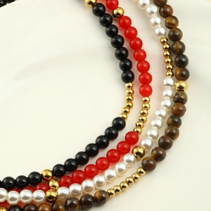 Close-up of pearl and natural stone necklaces with gold beads in four different colors