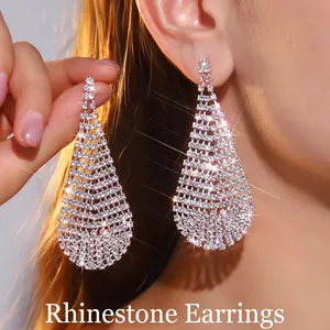 Close-up of sparkling long teardrop fringe earrings with multi-row rhinestone mesh