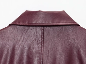 Dettaglio della giacca in pelle bordeaux con colletto a rever e cuciture di pregio
