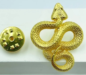 Macro detail of golden snake brooch with realistic scales and anti-slip clutch back