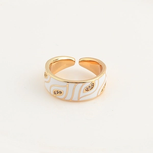 Detail of gold-plated open ring with white enamel waves and micro-set cubic zirconia