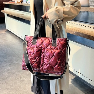 Metallic wine red quilted tote bag with double front pockets and black wide shoulder strap