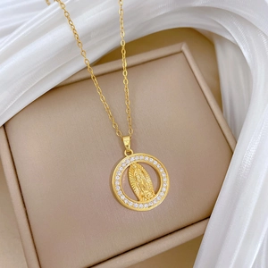 Detail of gold circular pendant necklace with central portrait and crystal accents