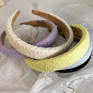 Macro shot of assorted colorful lace headbands showing fabric texture and padded style