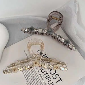 Elegant 13cm K9 crystal hair claw clip with floral stones on minimalist book background