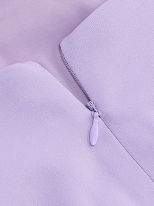 Close-up of purple twill fabric texture and hidden zipper detail on a V-neck dress