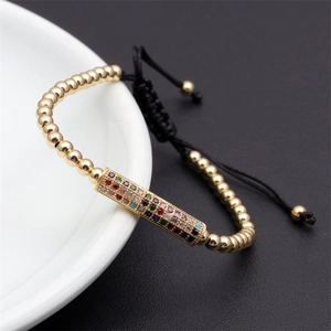 Detail of adjustable woven bracelet with colorful cubic zirconia and gold beads