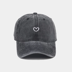 Close-up of heart embroidery on vintage washed dark grey cotton baseball cap texture