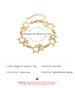 Détail du bracelet doré avec breloques étoiles ajourées et fermoir mousqueton robuste