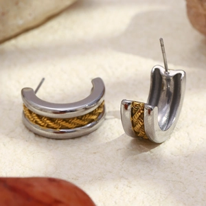 Détail de boucles d'oreilles C vintage avec design torsadé bicolore or et argent