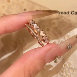 Macro detail of rose gold heart rings with mother of pearl and zircon micro-pave
