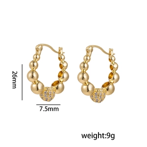 U-shaped gold beaded earrings with crystal accents and matte finish on white background