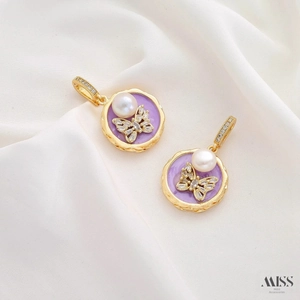 Detail of purple enamel pendant with pearl and butterfly motif in a golden frame