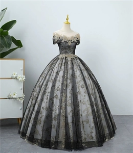 Elegantes Abendkleid mit schwarzer und goldener Spitze auf Schaufensterpuppe.