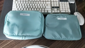 Detail of light blue waterproof makeup bags in two sizes with white fabric labels