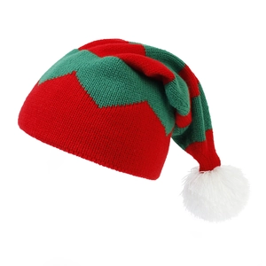 Close-up of red and green knitted Christmas hat featuring long tail and white pompom
