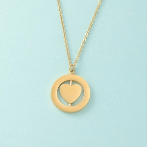Detail of a rotating heart pendant inside a gold circular frame on a fine chain