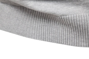 Gros plan des poignets et de l'ourlet gris montrant la texture détaillée du tricot