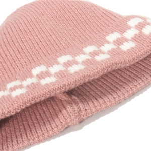 Close-up of pink knit beanie with white checkered pattern and soft ribbed texture