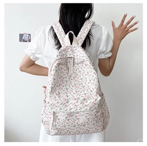 Detailed back view of a canvas floral backpack with pink flowers and adjustable straps