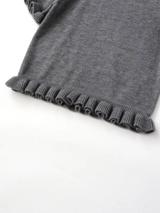 Detail showing the layered ruffle hem and fine knit texture of this grey top