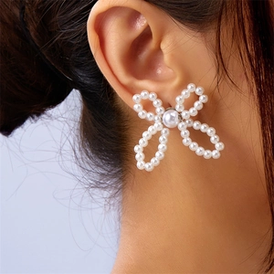 Close-up of bow knot pearl earrings worn by a model showcasing elegant detail