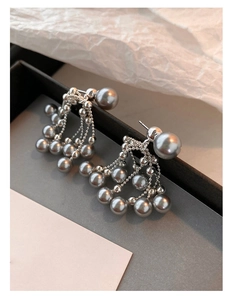 Detail of silver drop earrings with grey pearls and tassel fan design on white background
