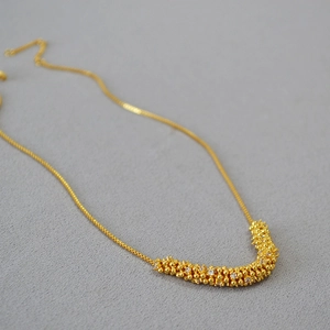 Elegante collana in ottone placcato oro con perle dorate e zirconi scintillanti