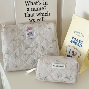 Close-up of quilted cosmetic bags set with pink bow detail and floral pattern