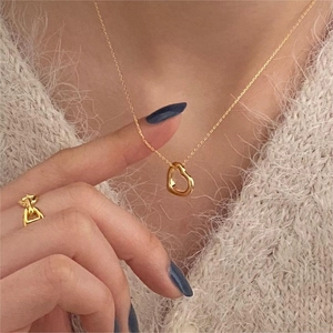 Minimalist gold 925 sterling silver heart necklace and open ring set worn by a model